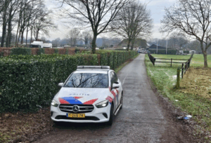 Politie auto op een pad bij een boerderij