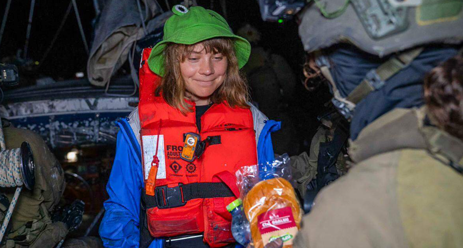 Greta Thunberg lacht met een soldaat