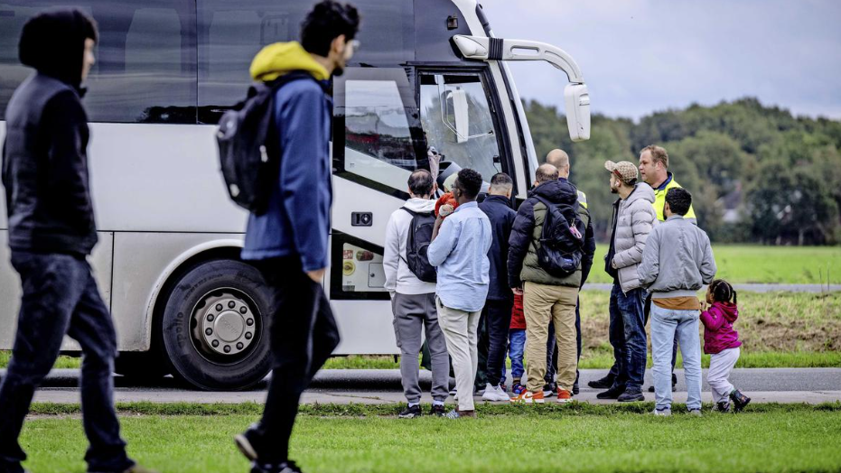 Asielzoekers stappen in een bus