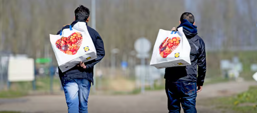 2 asielzoekers lopen met hun tas
