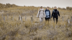 Mensen maken een wandeling in de duinen
